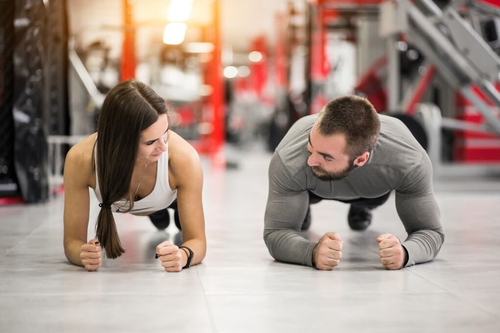یک مرد و یک زن تمرین پلانک را انجام می دهند که برای همه گروه های عضلانی طراحی شده است